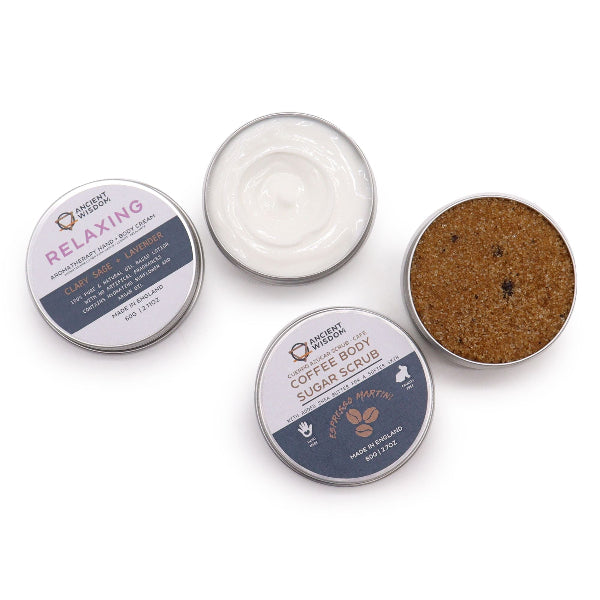 Collection of body care products including a cream, scrub, and scrubber on a white background