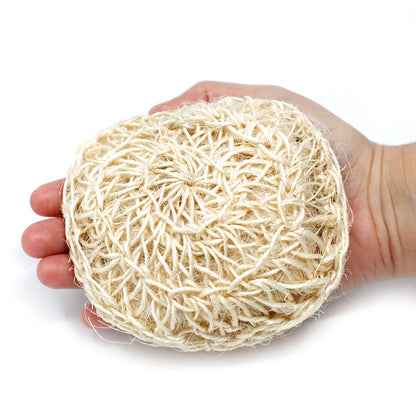 Hand holding a round, beige natural fiber product on a white background